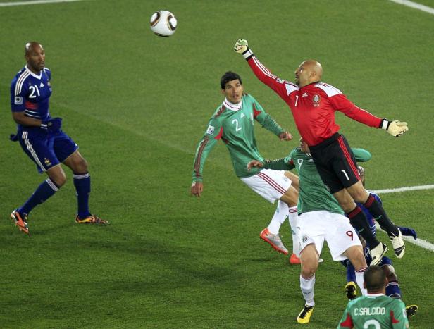 Ein Fußballspiel zwischen Frankreich und Mexiko, bei dem der mexikanische Torwart den Ball abwehrt.