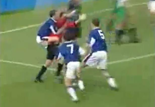 Fußballspieler in blauen Trikots kämpfen um den Ball auf dem Spielfeld.