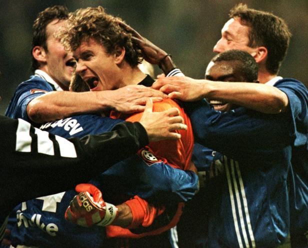 Eine Gruppe von Fußballspielern feiert ausgelassen einen Sieg.