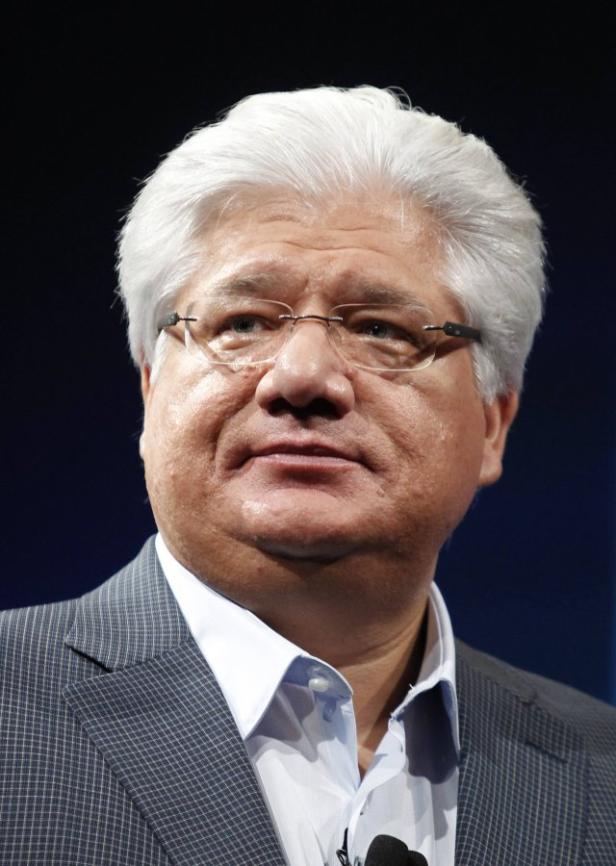 Ein Mann mit grauem Haar und Brille trägt einen Anzug.