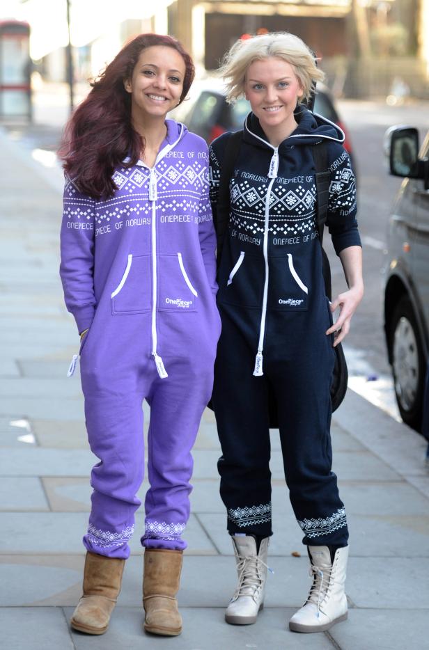 Zwei Frauen posieren in Norwegen-Einteilern und Stiefeln auf einem Gehweg.