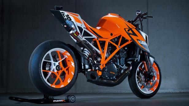 Ein orangefarbenes KTM-Motorrad steht auf einem Montageständer.