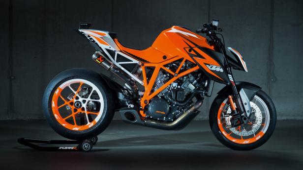 Ein orangefarbenes KTM-Motorrad steht auf einem Montageständer.