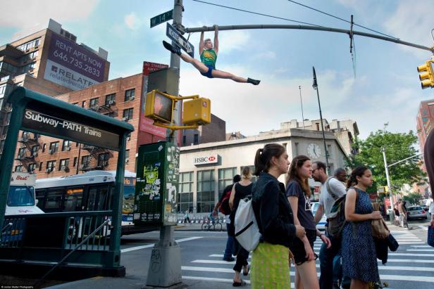 Eine Frau macht einen Spagat an einer Strassenlaterne in New York.