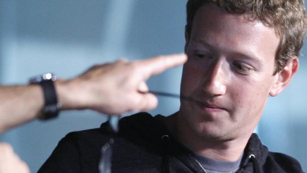 Mark Zuckerberg wird von einer Person mit dem Finger angetippt.