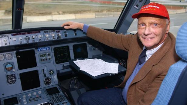 Ein Mann mit roter Kappe sitzt im Cockpit eines Flugzeugs.