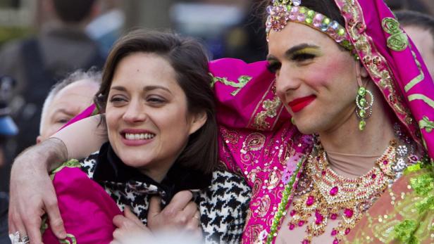Marion Cotillard umarmt einen Mann in auffälliger, indisch inspirierter Drag-Queen-Kleidung.