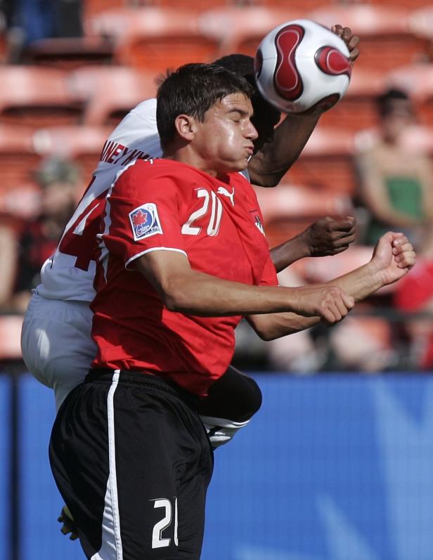 Zwei Fußballspieler kämpfen um den Ball bei einem Spiel.