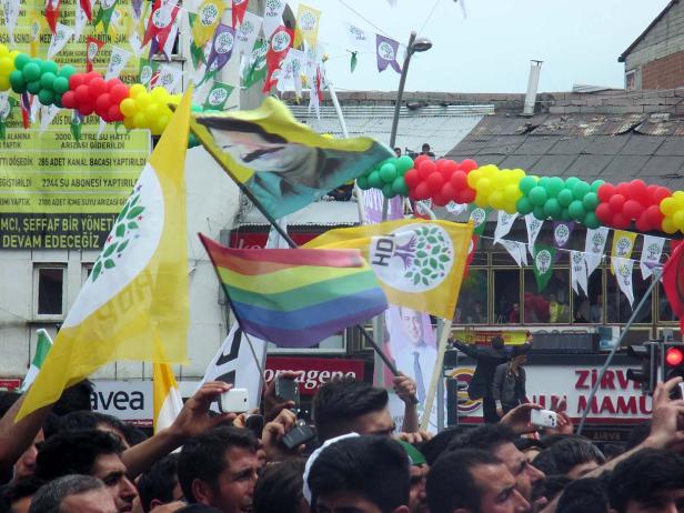 Eine Menschenmenge demonstriert mit HDP-Flaggen und Regenbogenfahnen.