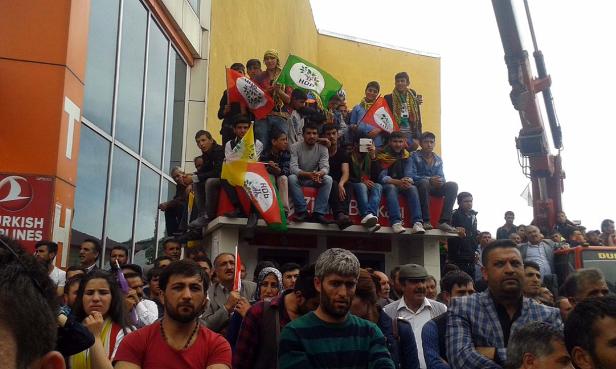 Eine Menschenmenge demonstriert mit HDP-Flaggen vor einem Gebäude.