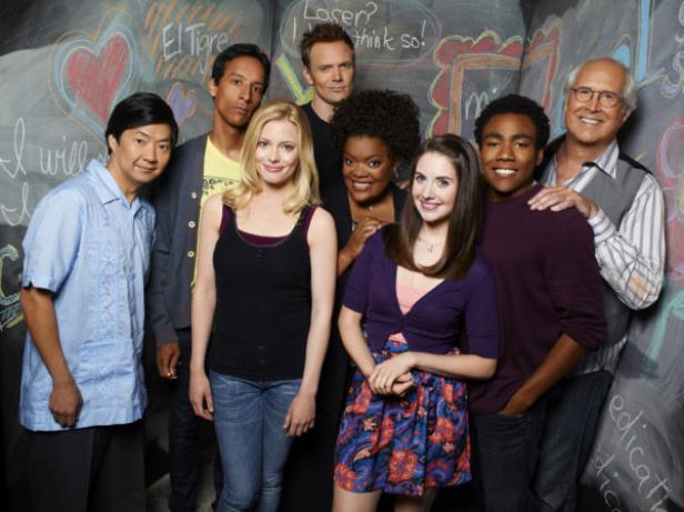 Die Besetzung der Fernsehserie „Community“ posiert vor einer Tafel.