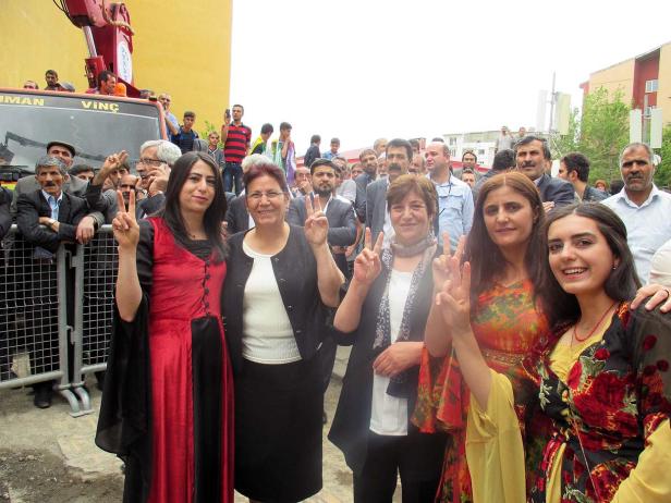 Eine Gruppe von Frauen und Männern zeigt das Friedenszeichen.