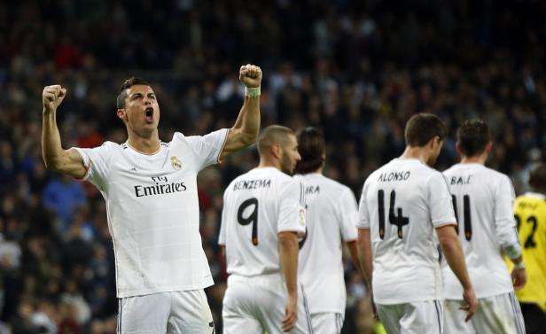 Cristiano Ronaldo jubelt mit erhobenen Fäusten, während seine Teamkollegen im Hintergrund stehen.