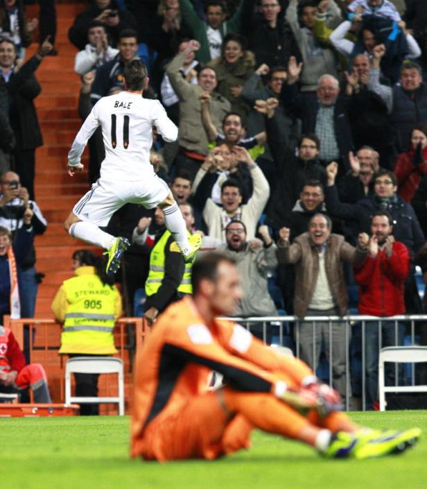 Gareth Bale von Real Madrid jubelt vor den feiernden Fans, während ein Torwart enttäuscht am Boden sitzt.
