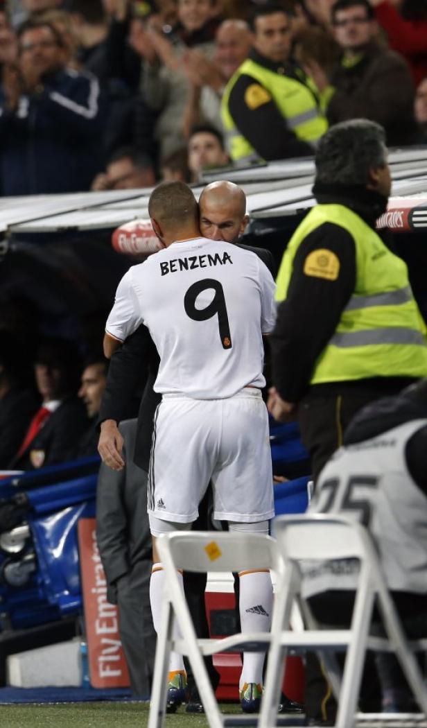 Zinedine Zidane umarmt Karim Benzema auf dem Spielfeld.