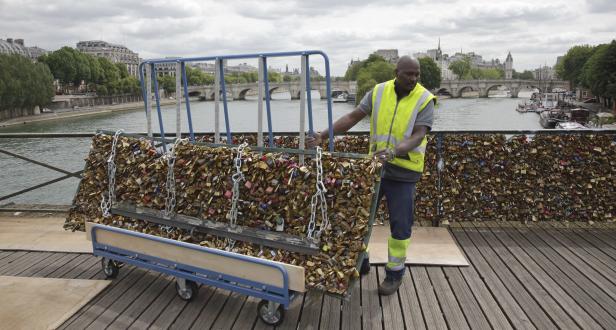 Ein Arbeiter entfernt Liebesschlösser von einer Brücke in Paris.