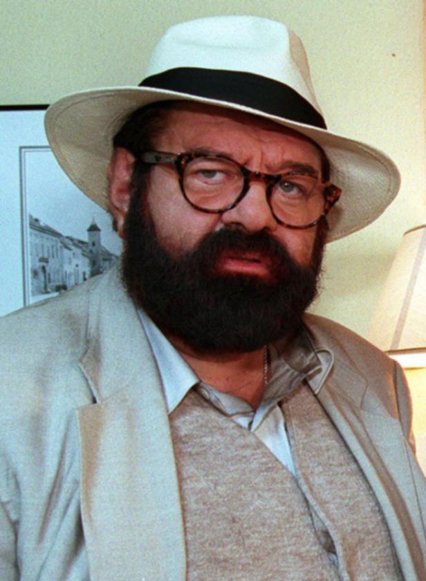 Ein Mann mit Bart, Brille und Hut blickt in die Kamera.