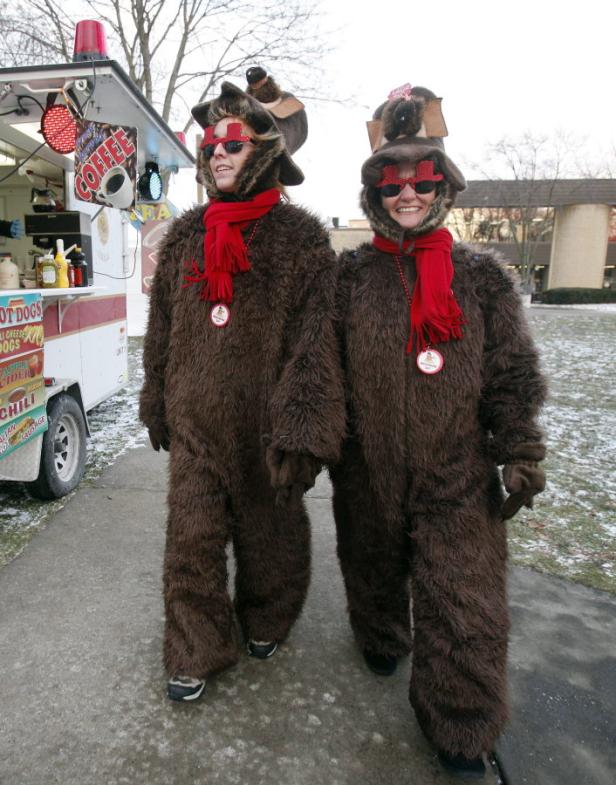 Zwei Personen in Biberkostümen stehen vor einem Imbisswagen.