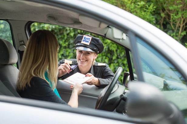 Eine Frau im Auto wird von einer Polizistin mit „Ritter Sport“-Mütze kontrolliert.