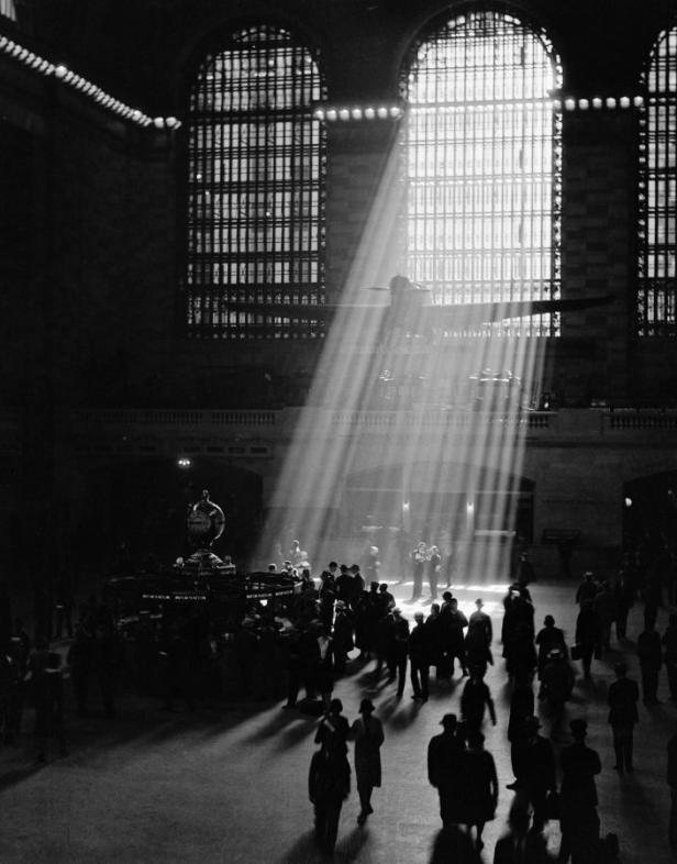 Sonnenstrahlen fallen durch die Fenster der Grand Central Station auf Menschenmengen.