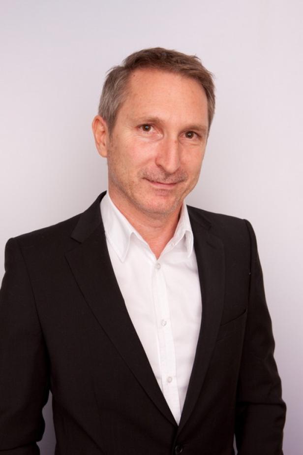 Michael Trauer, Sendungsverantwortlicher Guten Abend Österreich - Puls 4. (c: prosiebensat1 puls 4) Ein Mann mit Anzug und weißem Hemd lächelt in die Kamera.