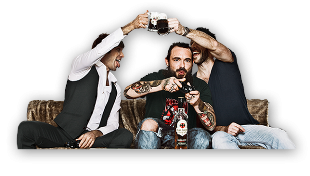 Drei Männer sitzen auf einer Couch, spielen Videospiele, stoßen mit Bierkrügen an und haben eine Flasche Bacardi dabei.