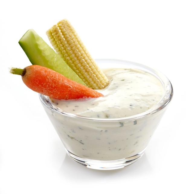 Gemüsesticks wie Karotte, Gurke und Maiskolben in einem Dip.