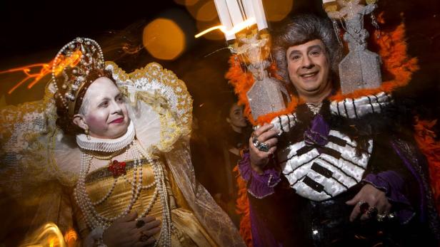 Zwei Personen in extravaganten Kostümen posieren für ein Foto.