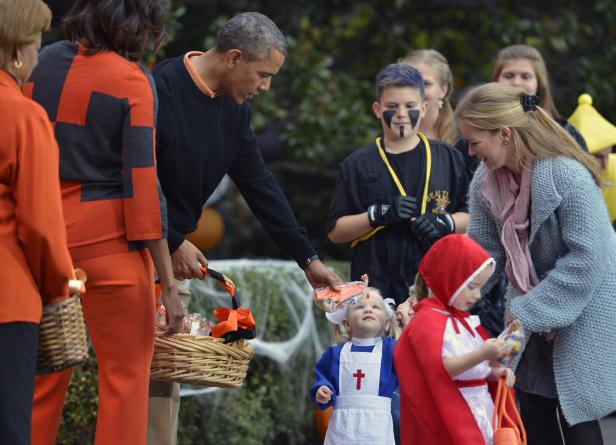 Barack Obama verteilt Süßigkeiten an Kinder in Halloween-Kostümen.