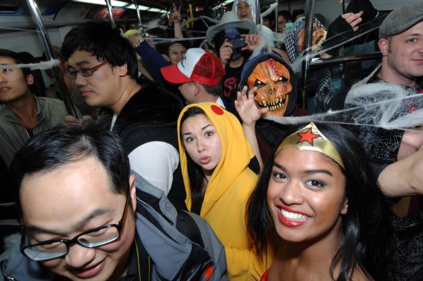 Menschen in Halloween-Kostümen fahren mit der U-Bahn.