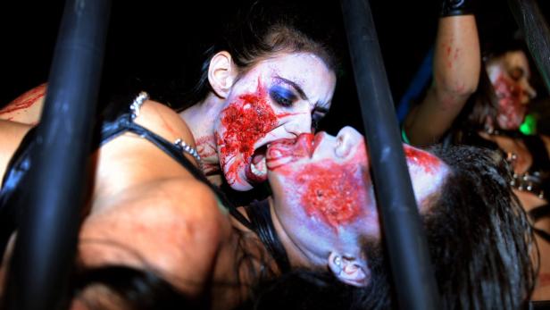 Zwei Frauen mit blutverschmierten Gesichtern scheinen sich zu küssen.