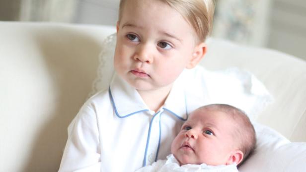 Prince George and Princess Charlotte are seen in t Prinz George hält seine neugeborene Schwester Prinzessin Charlotte im Arm.