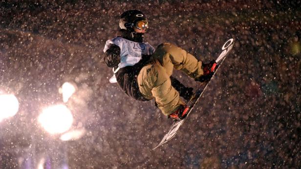 Ein Snowboarder springt bei starkem Schneefall in der Luft.