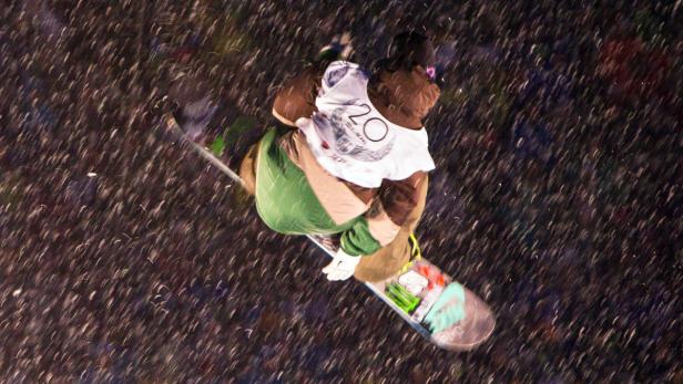 Ein Snowboarder springt in der Luft während eines Schneefalls.