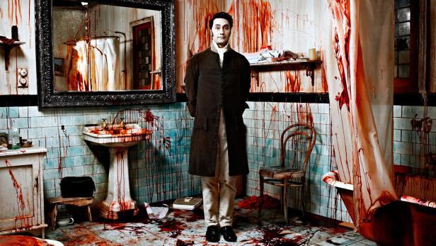 Taika Waititi steht in einem blutverschmierten Badezimmer.