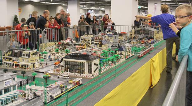 Eine Lego-Stadt mit Eisenbahn und vielen Zuschauern.
