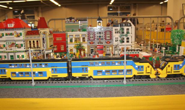 Eine Lego-Eisenbahn fährt vor einer Lego-Stadt.