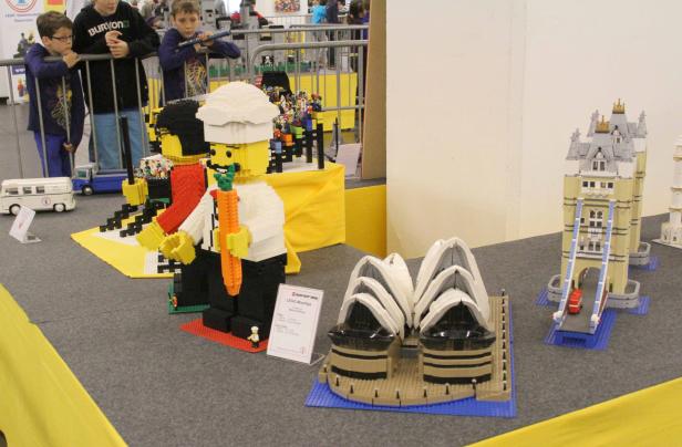 LEGO-Modelle des Sydney Opera House, des Tower Bridge und einer Kochfigur auf einer Ausstellung.