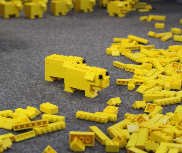 Ein gelbes Lego-Schwein inmitten loser Legosteine.