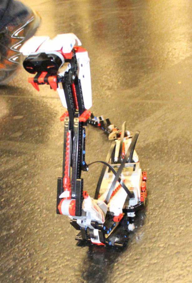 Ein Schlangenroboter aus Lego steht auf einem glänzenden Untergrund.