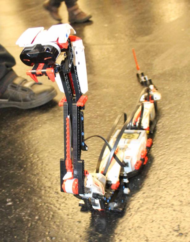 Eine Schlange aus Lego-Technik steht auf einem glänzenden Boden.