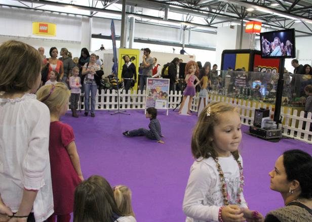 Auf einer Lego-Veranstaltung spielen Kinder auf einem lila Teppich.