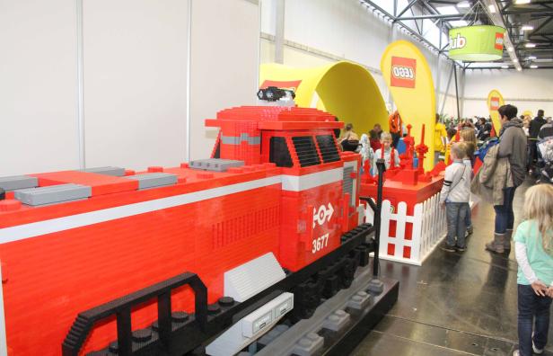 Eine rote Lokomotive aus Legosteinen auf einer Ausstellung.