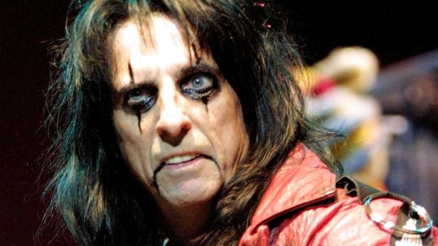 Alice Cooper mit starkem Make-up und roter Lederjacke.