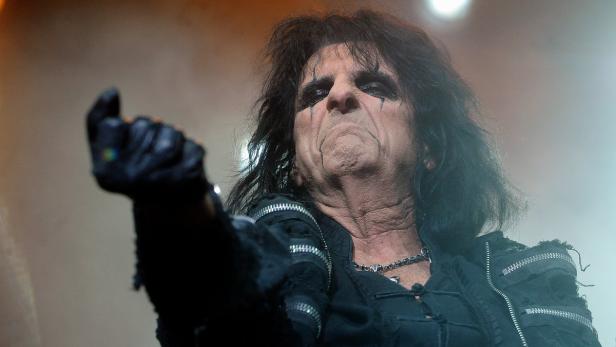 Alice Cooper mit dunklem Make-up und Lederhandschuhen während eines Auftritts.