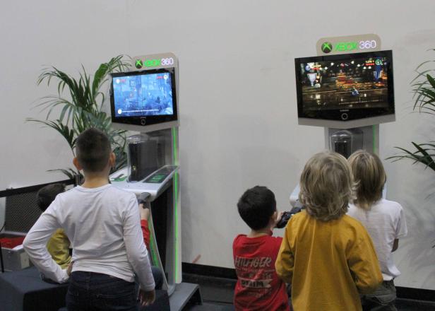 Kinder spielen an zwei Xbox 360 Spielkonsolen.
