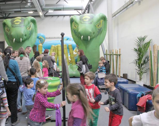 Kinder spielen in einem Indoor-Spielbereich mit aufblasbaren Schlangen.