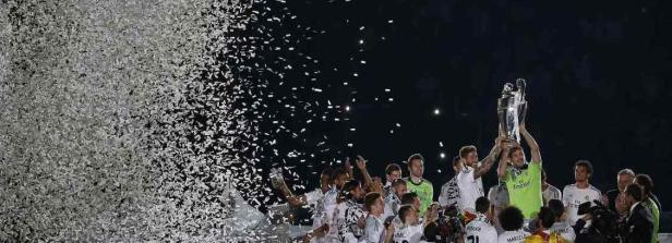 Real Madrid feiert einen Titelgewinn mit Konfetti und dem Pokal in der Luft.