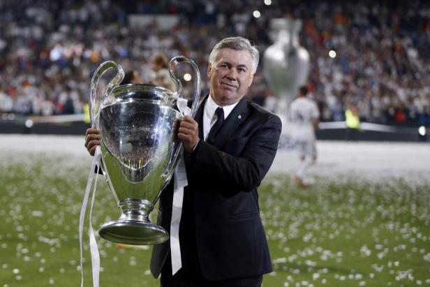 Carlo Ancelotti hält die Trophäe der UEFA Champions League in den Händen.