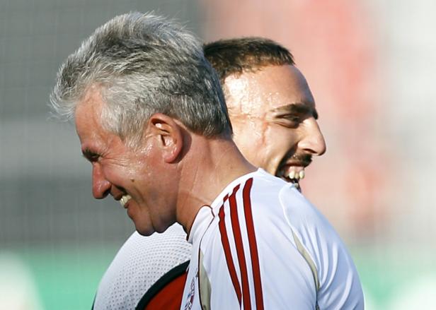 Zwei Fußballspieler in Trikots des FC Bayern München lachen.